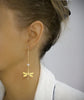 Woman wearing 18K gold plated dragonfly and diamond-cut crystal stud earrings.