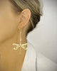 Woman wearing 18K gold plated statement dragonfly earrings decorated with Golden Shadow Swarovski crystals.