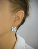 Woman wearing rhodium plated butterfly earrings with Swarovski crystal charms