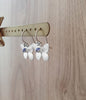 Rhodium plated butterfly earrings featuring Tanzanite Swarovski crystal charms on jewellery display