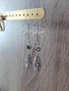 Rhodium plated dragonfly earrings adorned with grey Swarovski® crystal pavé drops on display.