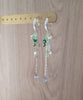 Silver hoop earrings with Peridot Green Swarovski butterflies and olive/emerald crystals on display