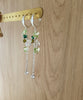 Silver hoop earrings featuring Peridot Green Swarovski butterflies and olive/emerald crystals on display