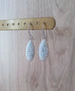 Timeless silver earrings adorned with white Swarovski crystal pavé pendants on display.