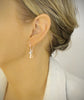 Woman wearing rhodium plated earrings with Golden Shadow Swarovski crystal drops and charms